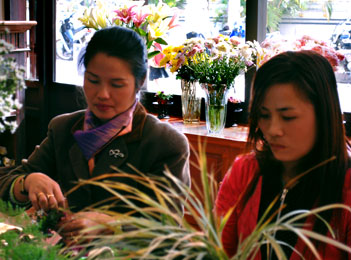 Préparation aux Jardins de l'Elephant de bouquets de fleurs pour une cérémonie Two workers are making flowers for a ceremony