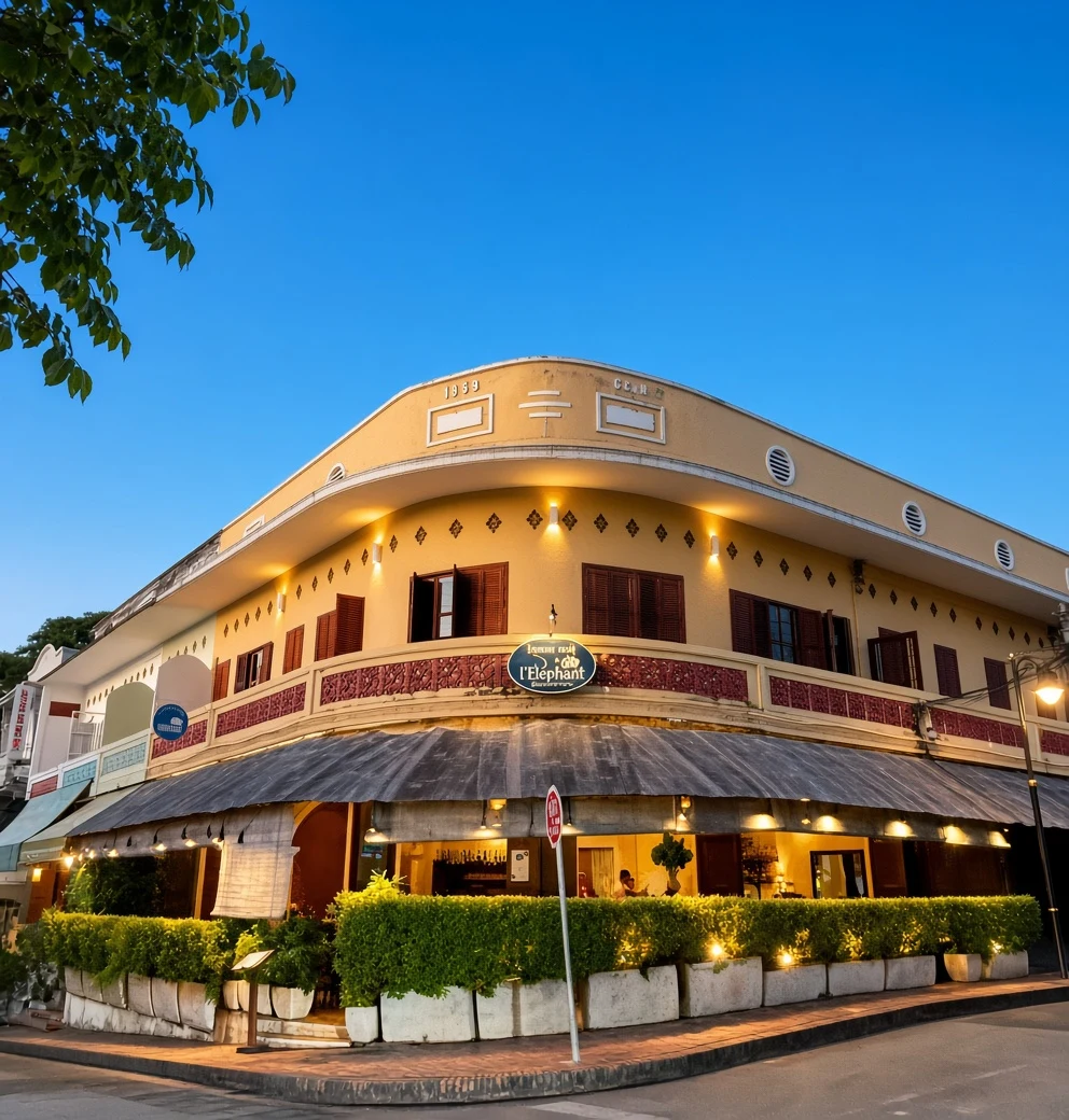 La façade d’angle de L’Éléphant et sa véranda illuminée à Luang Prabang.